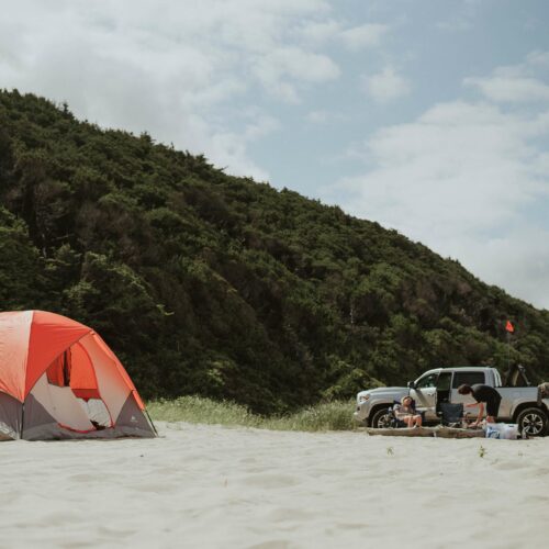 contrôler son véhicule avant les vacances Pick-up posé sur le sable à côté d'une tente de camping